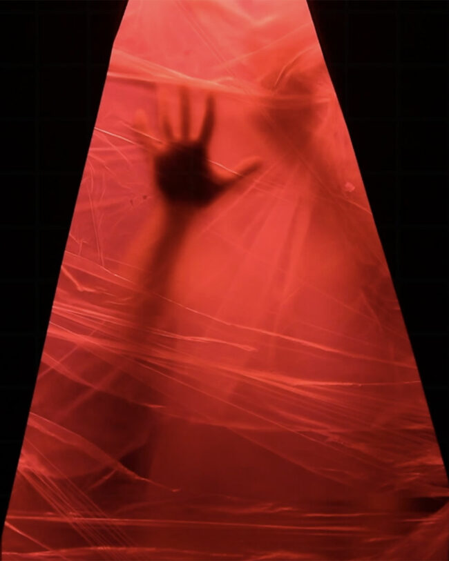 silhouette of hands on a plastic wall illuminated with red light